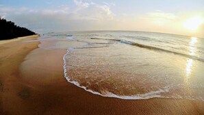 Une plage aux vagues douces et sous un ciel dégagé.