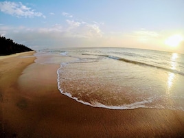 Uma praia com ondas suaves e céu claro.