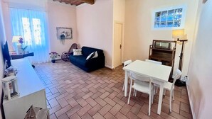 Un soggiorno con divano, tavolo da pranzo con sedie, televisore e camino.