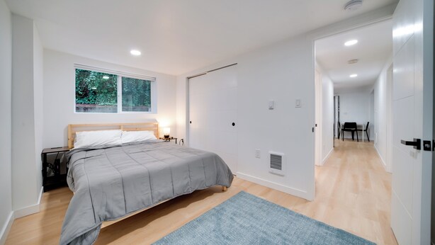 Une chambre à coucher moderne avec un lit, une fenêtre, un bureau et une chaise.