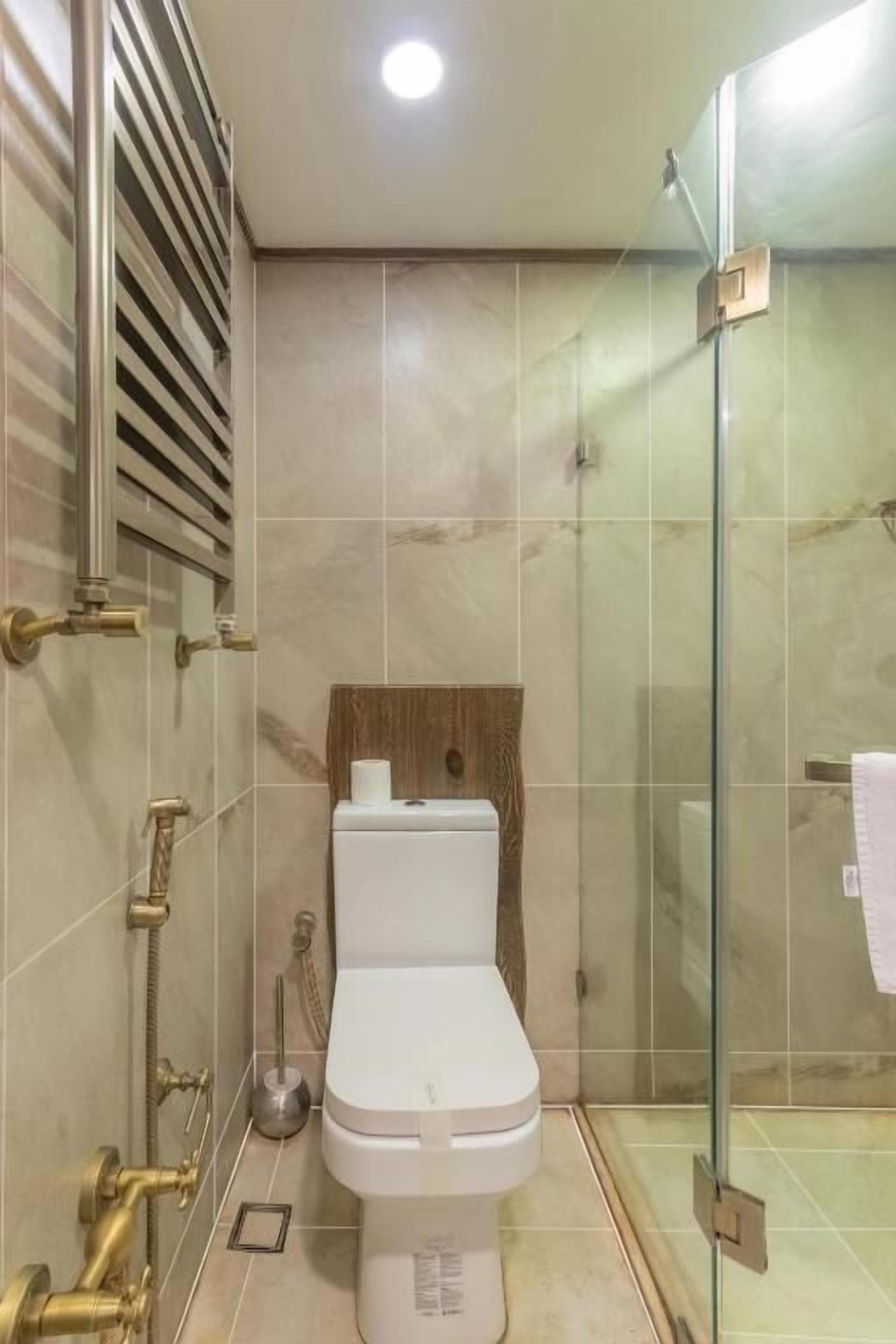 Une salle de bain moderne équipée de toilettes, d’une douche et d’une paroi de verre.