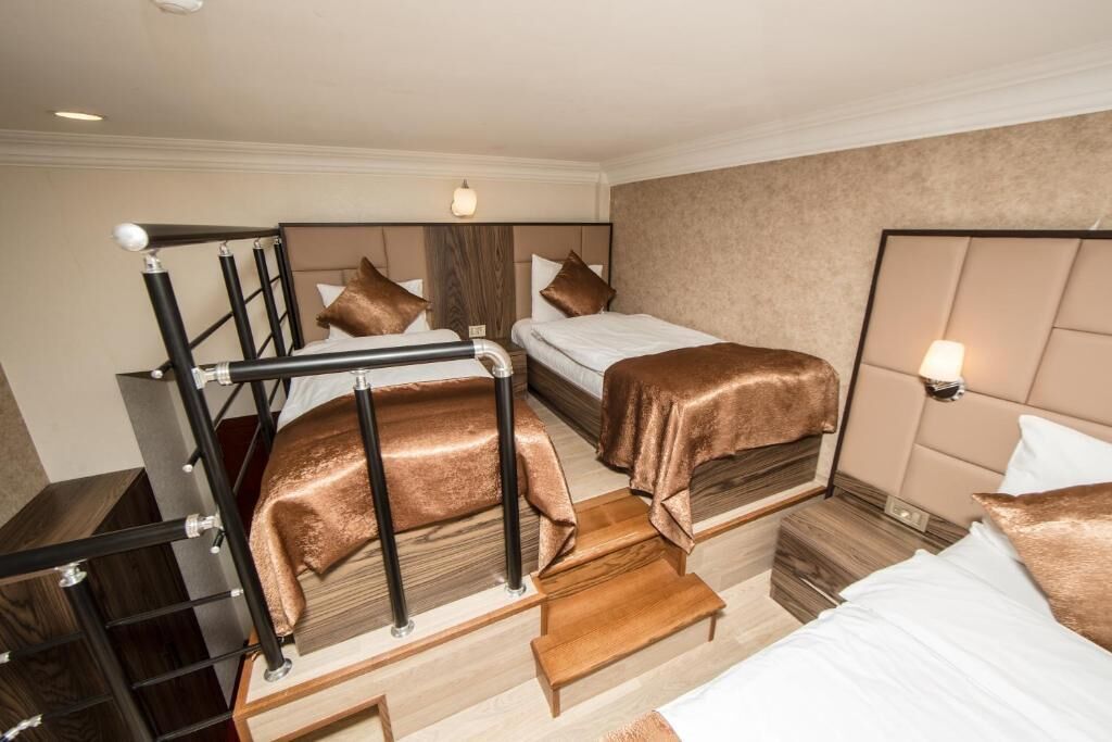 Una habitación de hotel con literas, un escritorio y una mesita de noche.