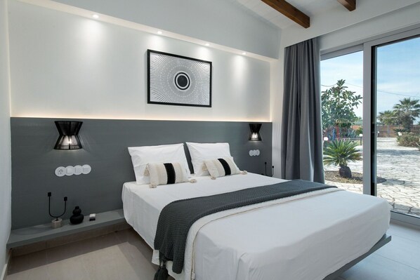 A modern bedroom with a large bed, a ceiling light, and a view of the outdoors.