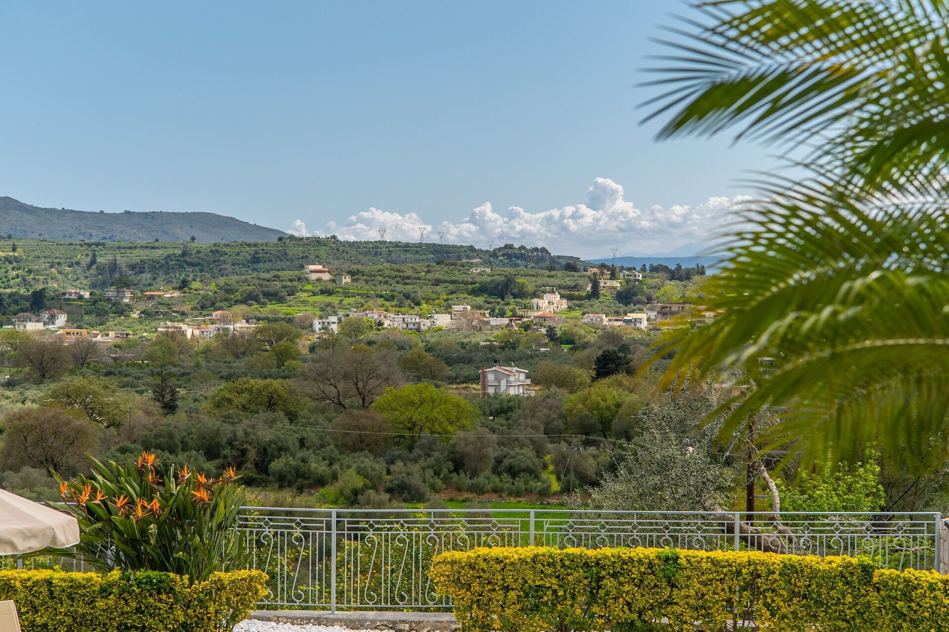 Une vue pittoresque d’un village perché sur une colline, avec ses maisons traditionnelles, sa végétation luxuriante et un ciel dégagé.