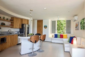 Relax in this open-plan living space with a kitchen area, central island, and comfortable seating.