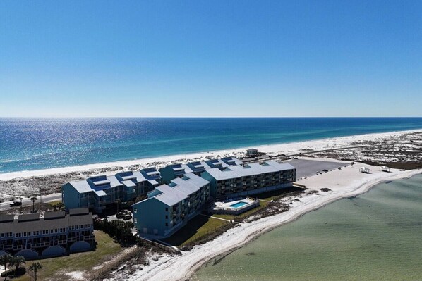 Un resort con varias edificaciones, piscina y playa.