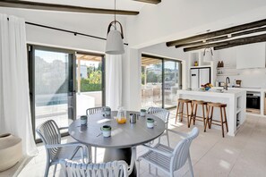 Enjoy meals at the central island or dining table, surrounded by a view of the outdoors.
