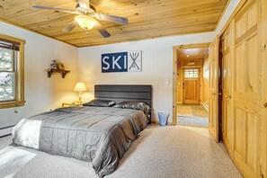 Relax in a cozy bedroom with a large bed and ceiling fan, perfect for a restful stay.