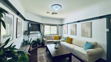 Una sala de estar con un sofá, una mesa de centro y varias plantas.
