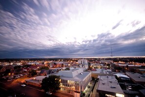 A cityscape at dusk with illuminated buildings and a clear sky. - 4BR Central Dubbo Family Home, 2 Living Areas, Large Backyard, Sleeps 8 (Dubbo)
