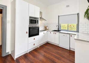 A modern kitchen with white cabinetry, a stainless steel oven, a microwave, and a dishwasher. - 4BR Central Dubbo Family Home, 2 Living Areas, Large Backyard, Sleeps 8 (Dubbo)