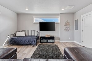 Un dormitorio con una cama, un televisor, una mesita, una alfombra y una pared con citas inspiradoras.