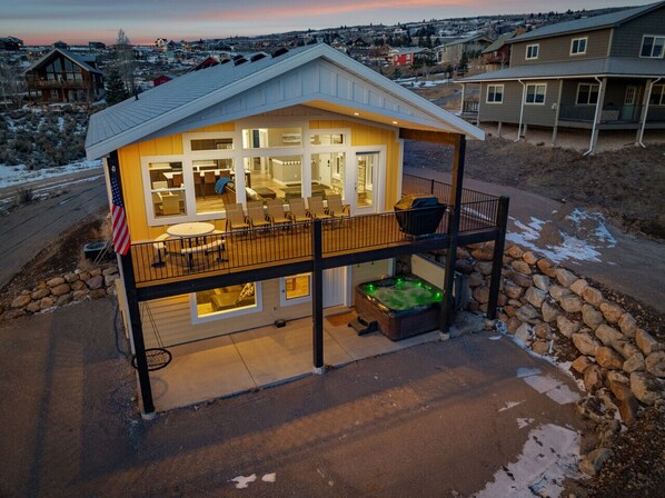 A two-story house with a balcony, a hot tub, and a view of the surrounding neighborhood.