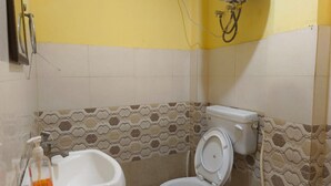 Ein kleines Badezimmer mit Toilette, Bidet und einer Handseifen-Spender.