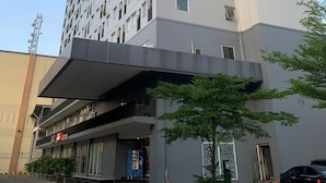 A multi-story hotel with a modern design, featuring a flat facade and numerous windows. - Nemuru Stay BTC (Bekasi)