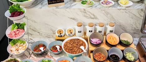 A variety of food items and condiments arranged on a marble countertop.