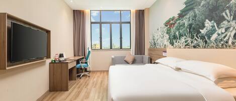Habitación de hotel con una cama grande, un escritorio con silla, un televisor de pantalla plana en la pared y un ventanal con vista a un edificio.