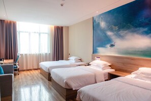 A hotel room with three beds, a desk, and a large painting of a boat on water.