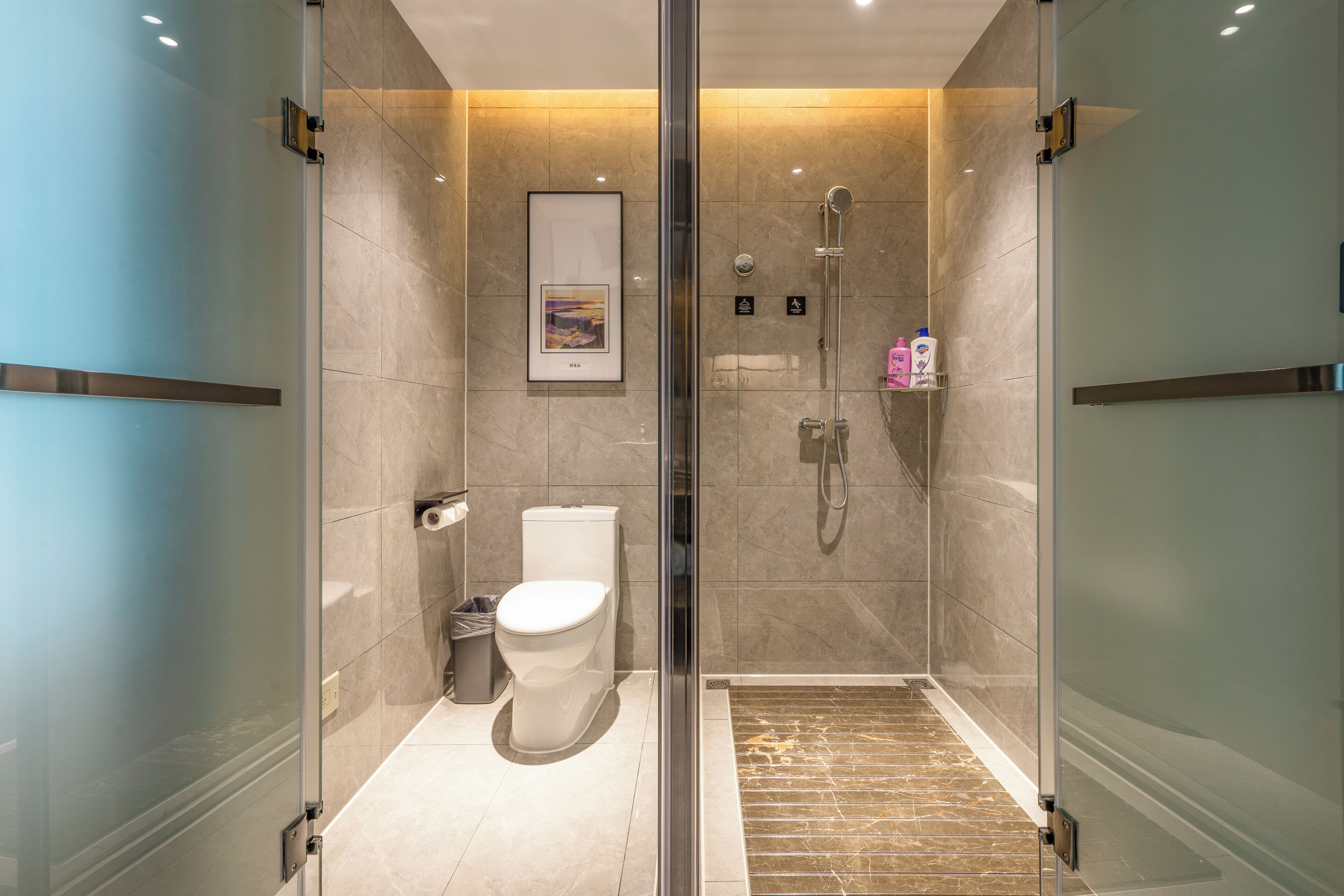 Une salle de bain moderne avec une douche à parois de verre, des toilettes et un lavabo.