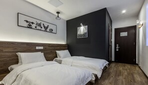 A hotel room with two single beds, a dark accent wall, and a framed picture of cats. - Yijian forest Tongji university branch (Shanghai)