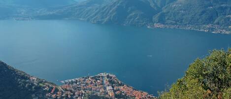 A coastal town with a view of a large lake and mountains in the background.