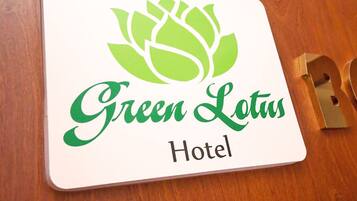 A hotel sign with the name "Green Lotus Hotel" and a lotus flower logo.