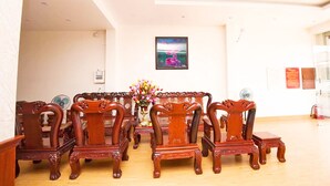 Un comedor con mesa y sillas de madera, un jarrón de flores y un cuadro en la pared.