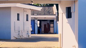 A building entrance with a tiled roof, a door, and a small window. - Kololo at 399 Guesthouse & Conference (Welkom)