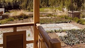 Un balcón de madera con vista a un paisaje montañoso.