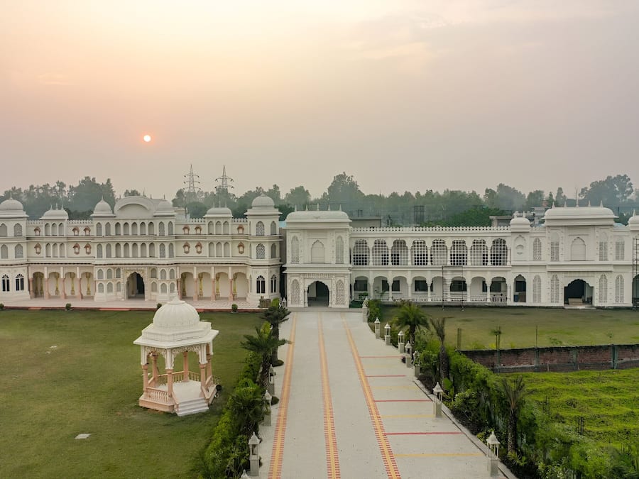 A large, white, multi-story building with a central courtyard and a symmetrical facade.