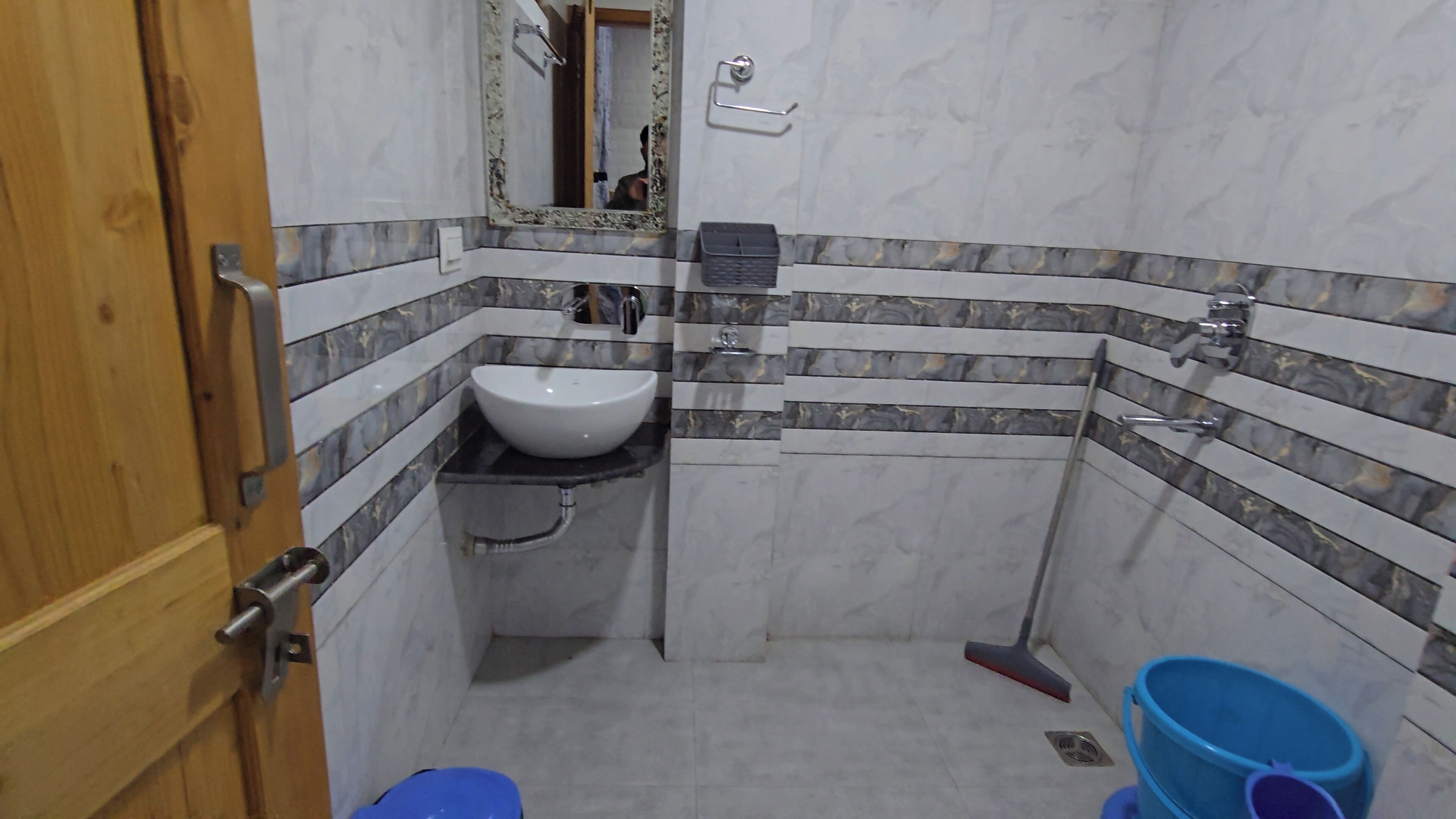 A bathroom with a white sink, a mirror, and a toilet.