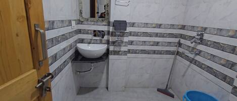 A bathroom with a white sink, a mirror, and a toilet.