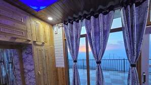 A room with wooden walls, a checkered floor, and a balcony with a railing. - Hotel HILL Mount View Dalhousie Chamba  (Dalhousie)