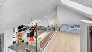 En modern inredning med ett kök, en matplats och ett vardagsrum med en soffa och en säng.