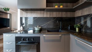 Una cocina moderna con horno empotrado, pileta y encimera decorada.