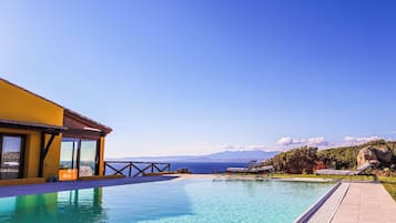 Una piscina al aire libre, tumbonas