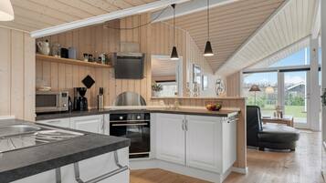 Une cuisine moderne avec des meubles en bois, un four encastré et un grand îlot central doté d’un évier.