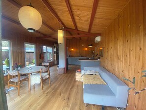 Un interior de madera con comedor, sofá y cocina.