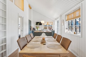 En matplats med ett långt bord, stolar och en centralt placerad dekorativ detalj.