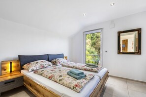 A bedroom with two beds, a window, a mirror, and a nightstand. - House with 4 Bedrooms, Shared Terrace, Garden & Wi-Fi in Solingen (Solingen)