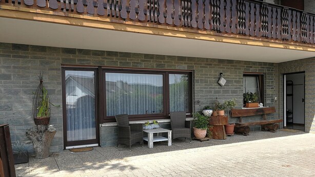 A building with a balcony, large windows, and potted plants. - Apartment 'Buedinger Weg' with Wi-Fi (Gründau)