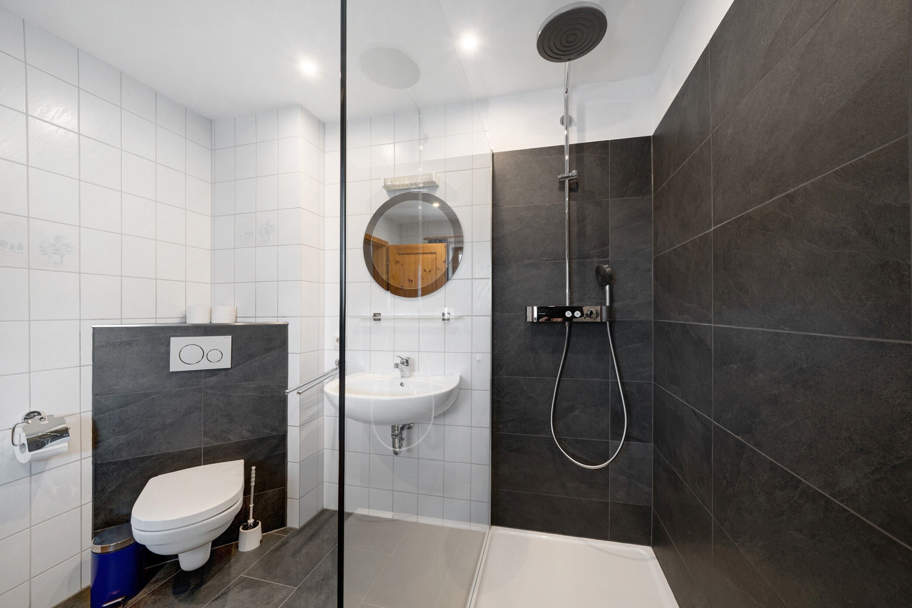 Une salle de bain moderne équipée de toilettes, d’un lavabo et d’une douche.