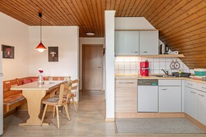 Eine moderne Küche mit Holzausstattung, einer roten Kaffeemaschine und einer gefliesten Spritzschutzwand.