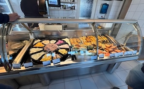 Un buffet proposant une variété de plats et indiquant les prix de chacun.