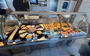 A buffet with various food items and price tags.