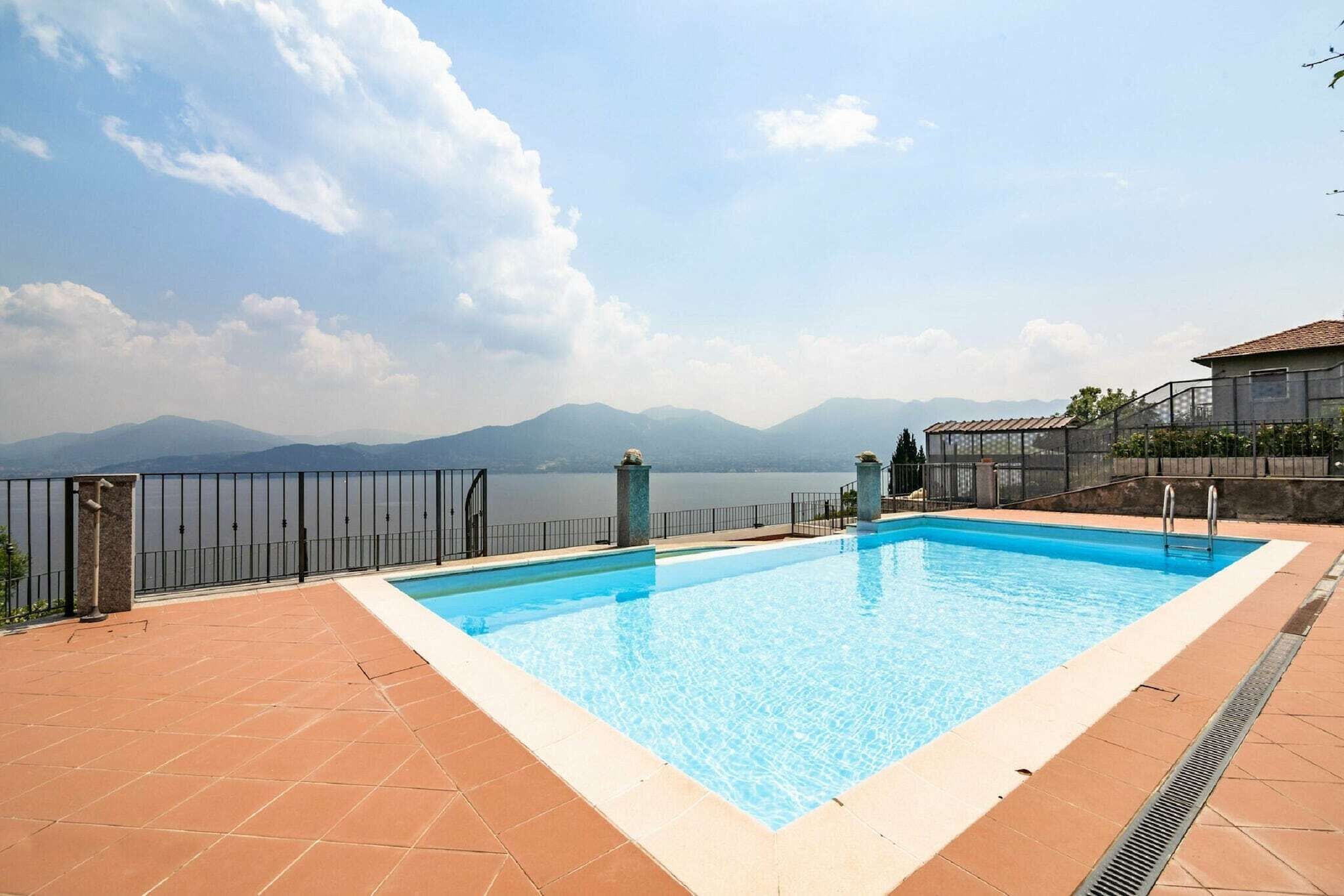 A rectangular swimming pool with clear blue water, surrounded by a tiled deck.