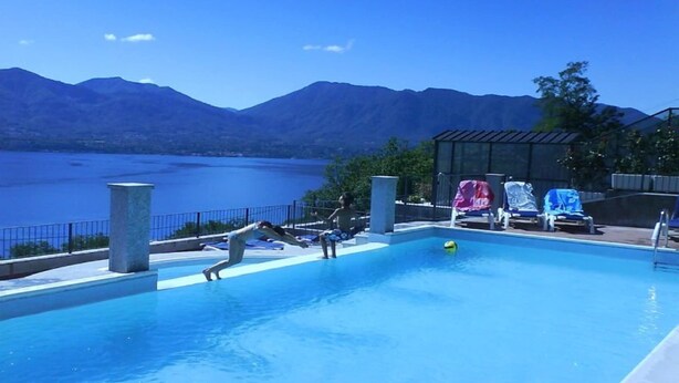 A swimming pool with a view of mountains and a lake. - Apartment in Oggebbio with Lake Maggiore Views (Oggebbio)