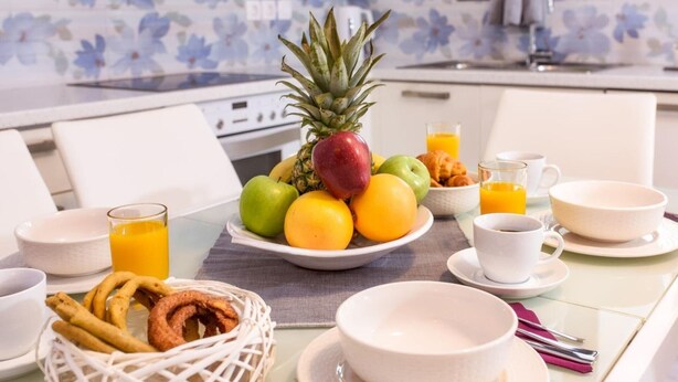 A breakfast setting with a fruit bowl, orange juice, croissants, and coffee cups on a table. - Alisahni Suite, Villa (Chania)