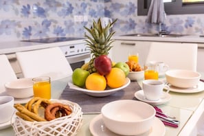 A breakfast setting with a fruit bowl, orange juice, croissants, and coffee cups on a table. - Alisahni Suite, Villa (Chania)