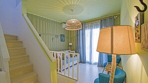 A staircase leading to a room with a crib, a hanging lamp, and a chair. - Alisahni Villa, Villa (Chania)